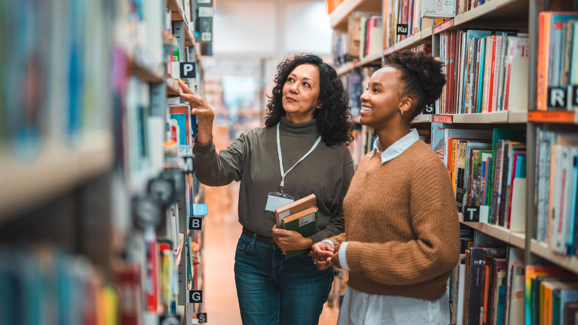 Librarian helping student finding a book